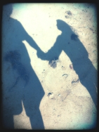 silhouette of dad and daughter holding hands on the beach 